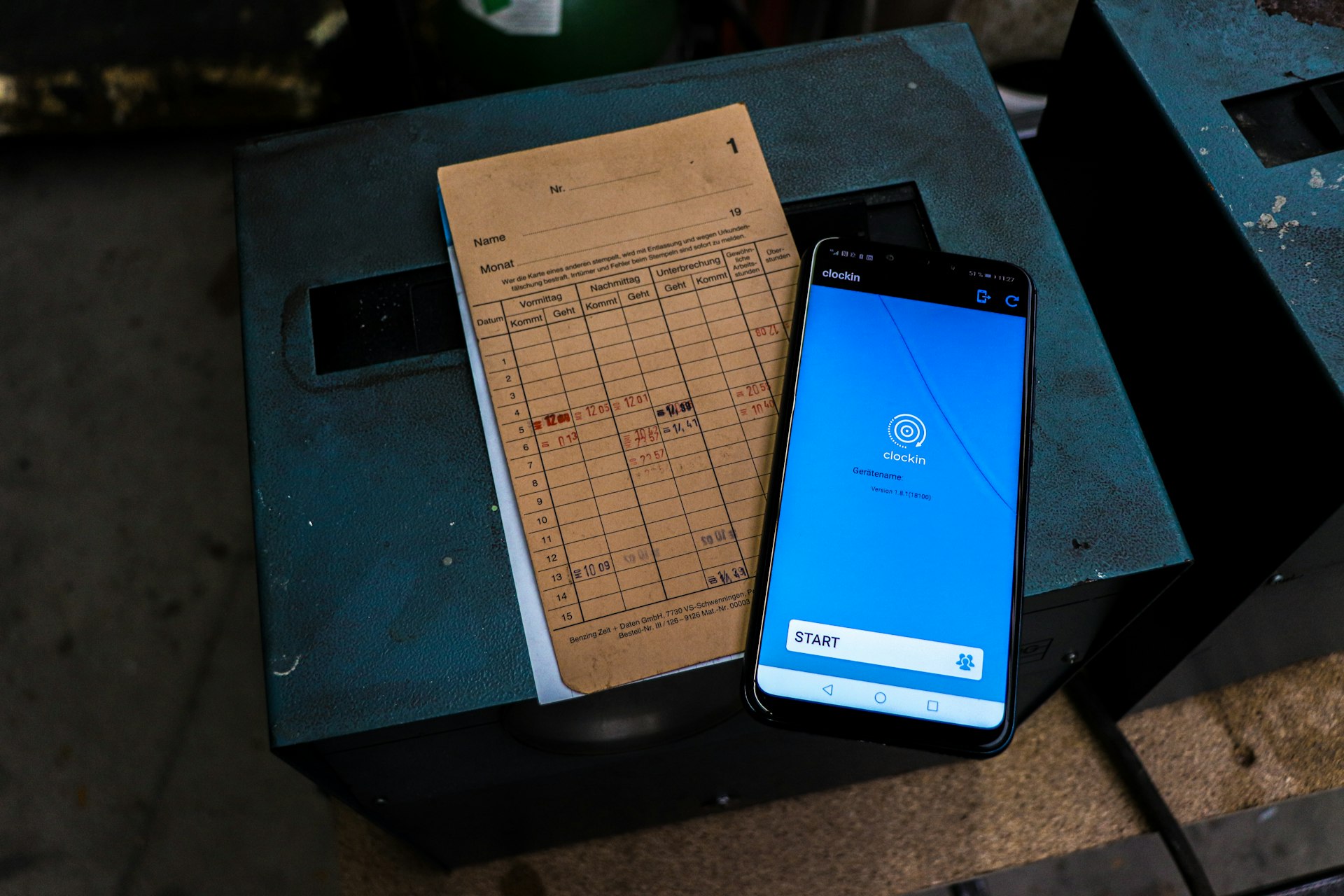 a cell phone sitting on top of a table next to a piece of paper